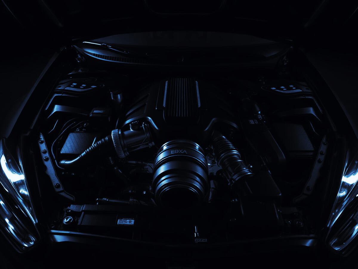 Engine bay of a modern car under low light